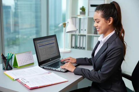 an HR employee doing employee backgroung checking with her laptop in her office