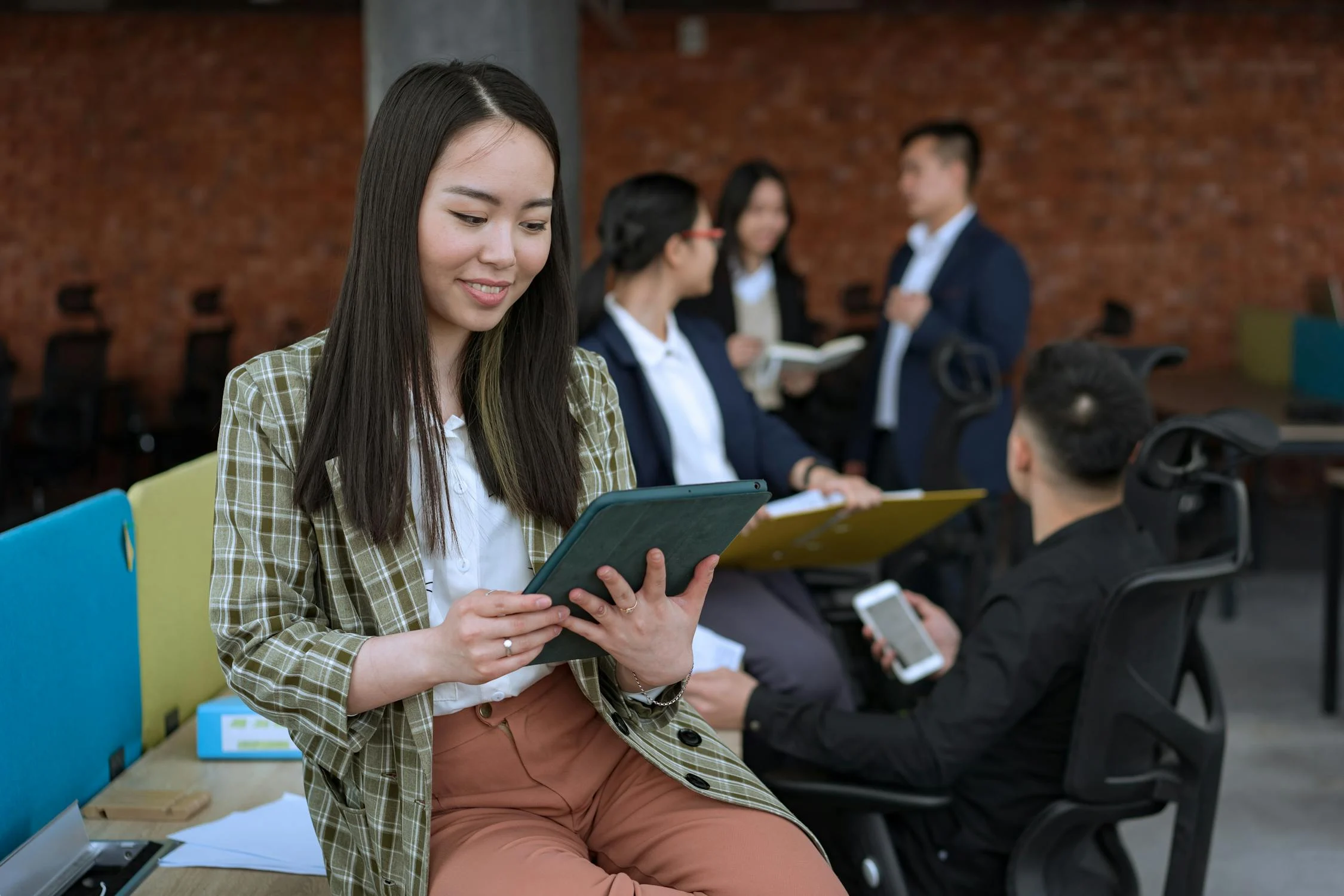 An employee using a tablet to clock in, representing digital attendance tracking in a modern workplace