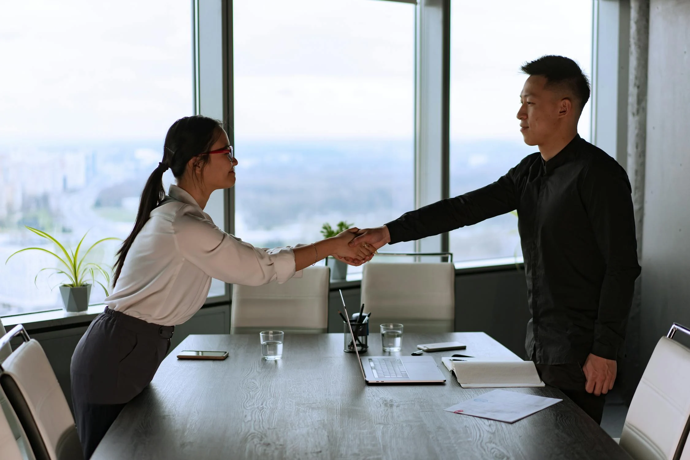 the employer shaking hand with the employee in a office