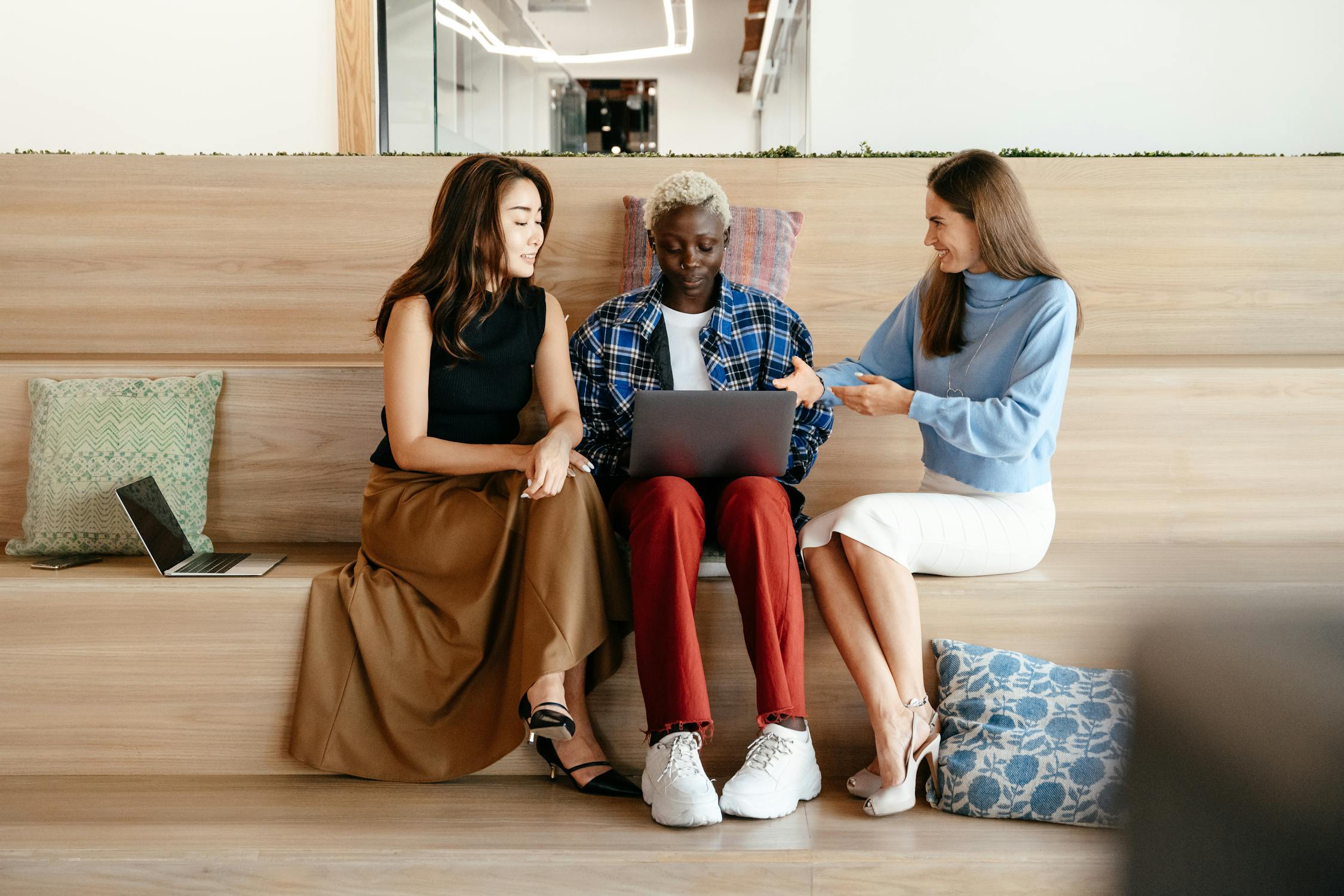 three employees gathered in lounge to chit-chat