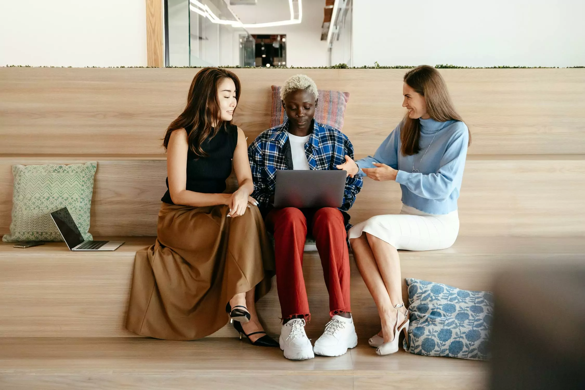 three employees gathered in lounge to chit-chat