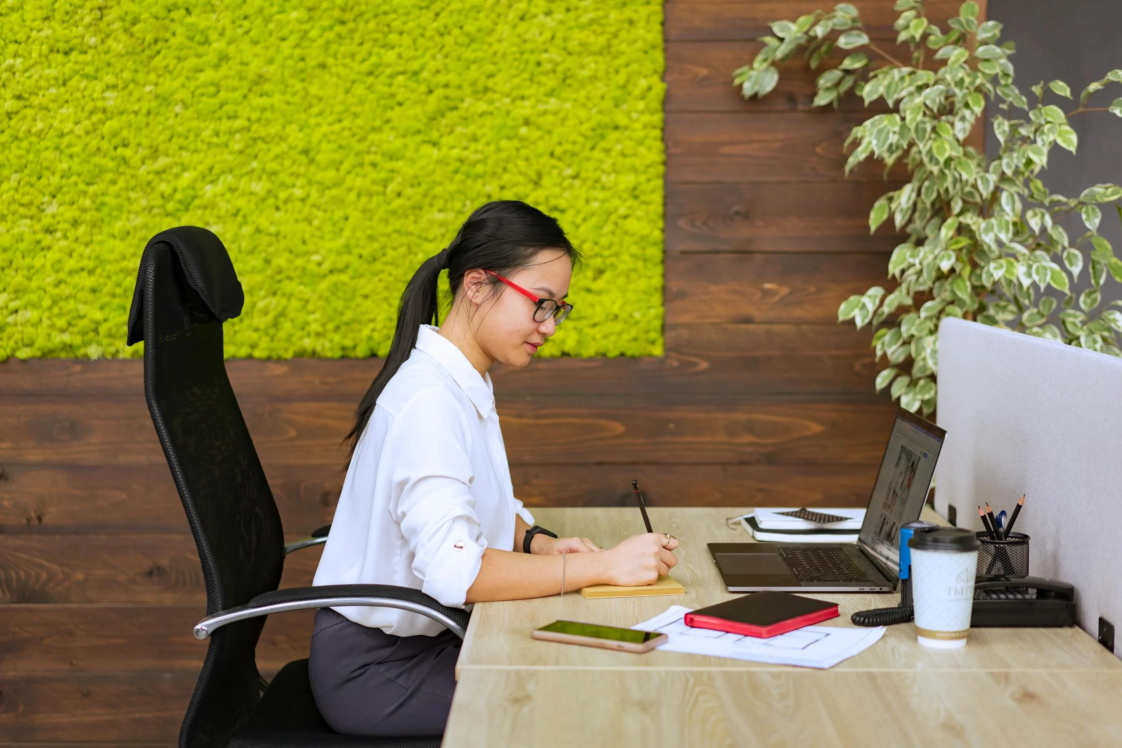 an employee working at her desk with a laptop in front of her