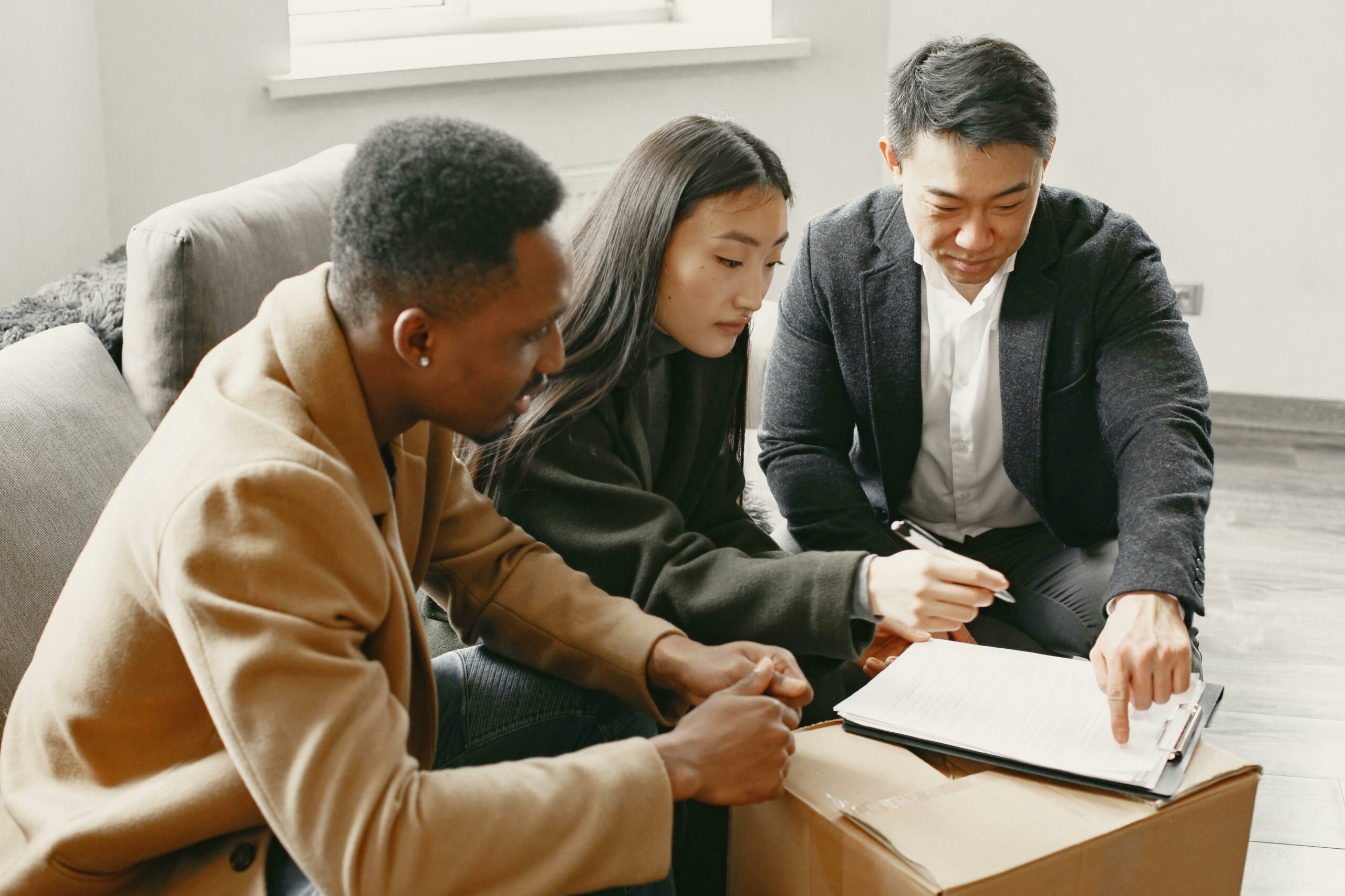 three employees gathered in a meeting room to discuss things together