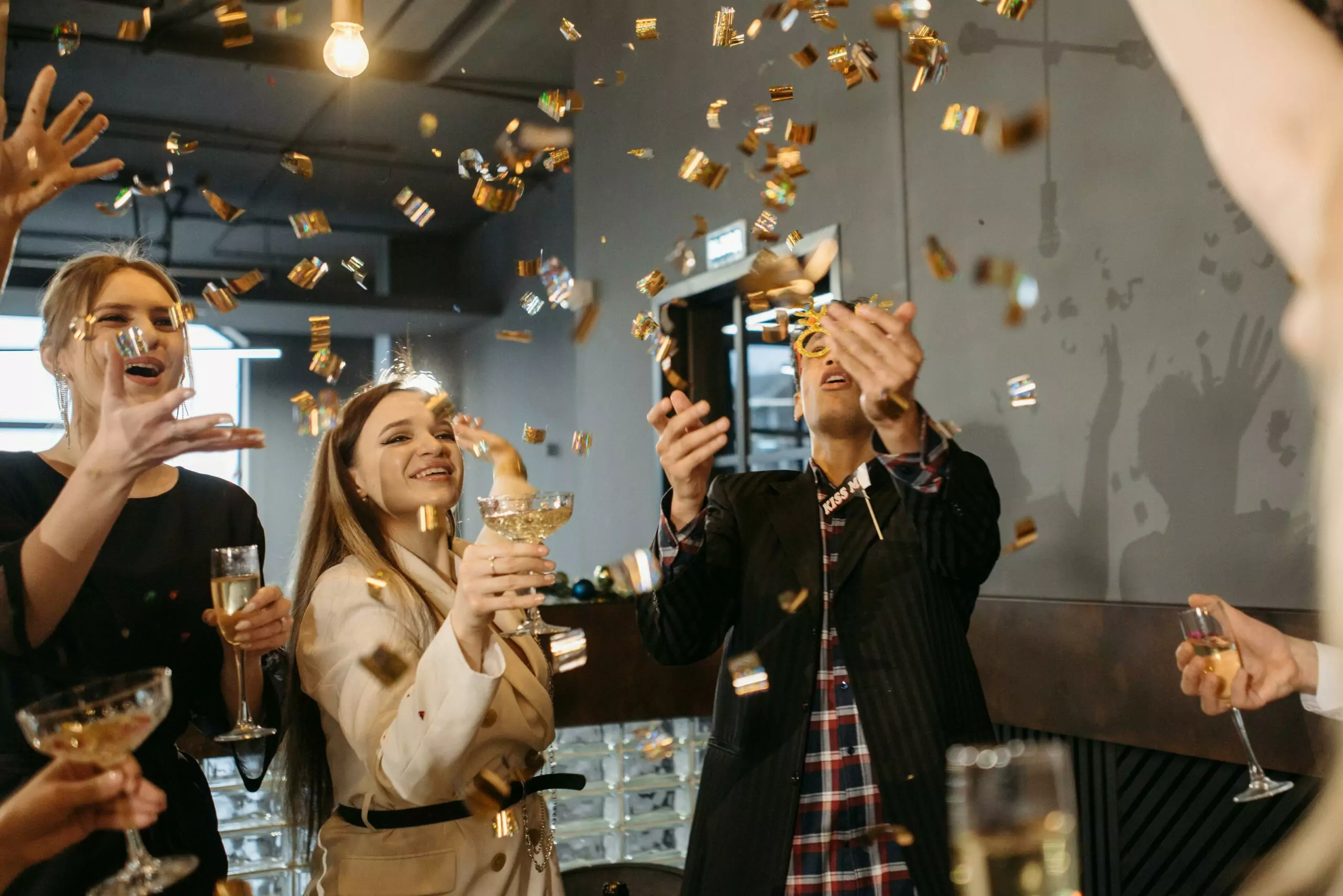A team celebrating achievement with gold confetti and champagne cheers