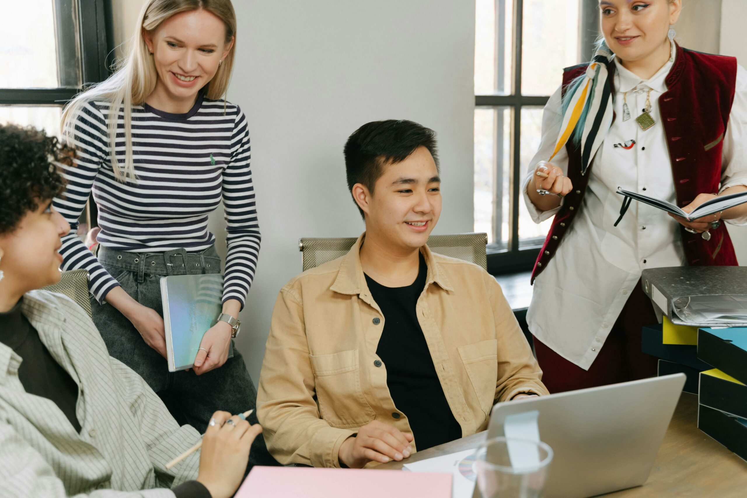 diverse employees gathered in a office to discuss work, and they are all in casual outfit