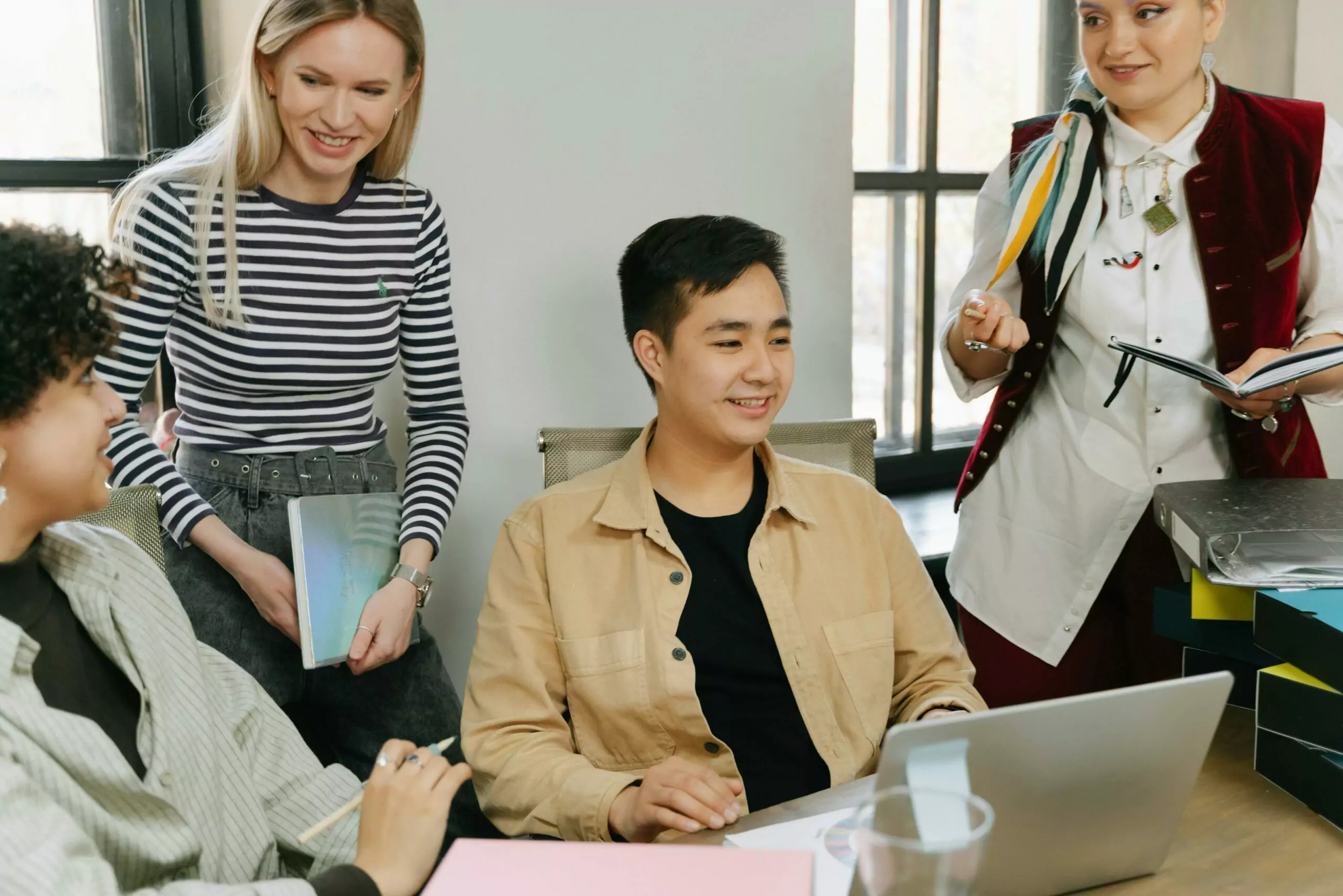 diverse employees gathered in a office to discuss work, and they are all in casual outfit